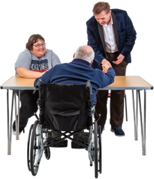 Man in wheelchair shaking hand of man behind a desk