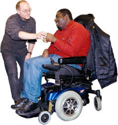 Man handing man in wheelchair a mug