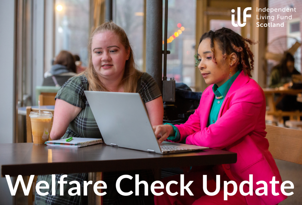 Two ladies sit a table in a cafe and look at a laptop. The lady on the left is white and blonde. She wears a tartan dress. She has a limb missing. On the right is a black lady. She wears a bright pink jacket and green shirt. Her dreadlocked hair has different colours at the ends. The ILF logo sits in the top right corner in white. Text at the bottom, in white, reads Welfare Check Update.
