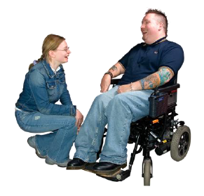 A man in a wheelchair talks to a lady who is kneeling down.