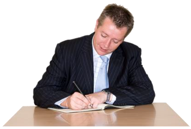 A man in a suit and blue tie sitting at a desk signing a document.