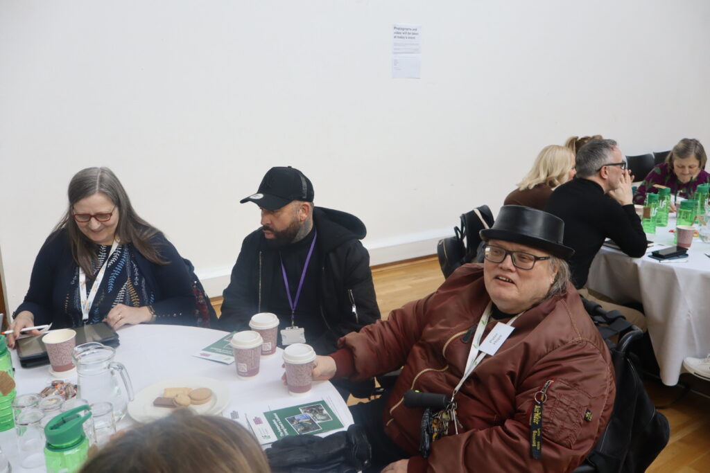 Participants at a table looking at someone off camera.
