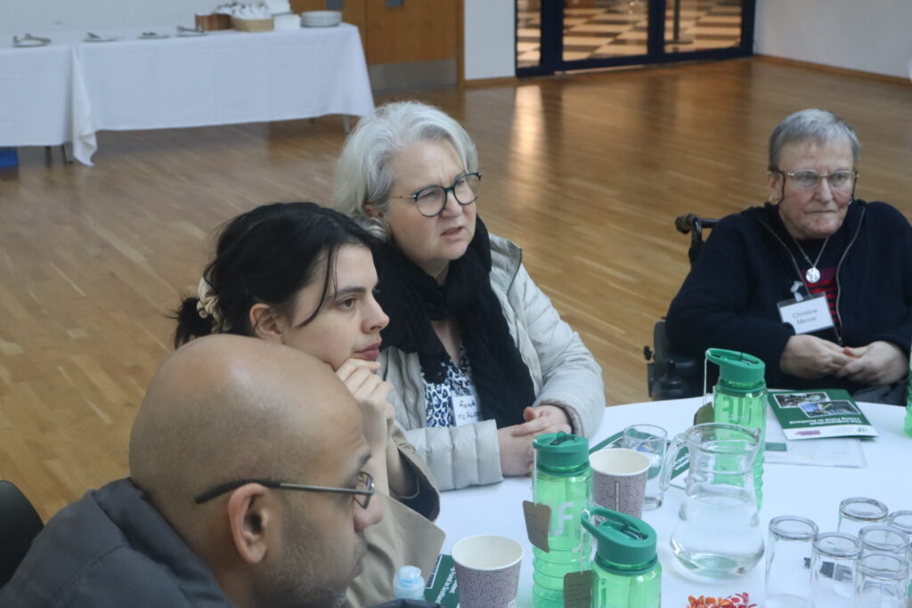 A table view of people listening to someone off camera.