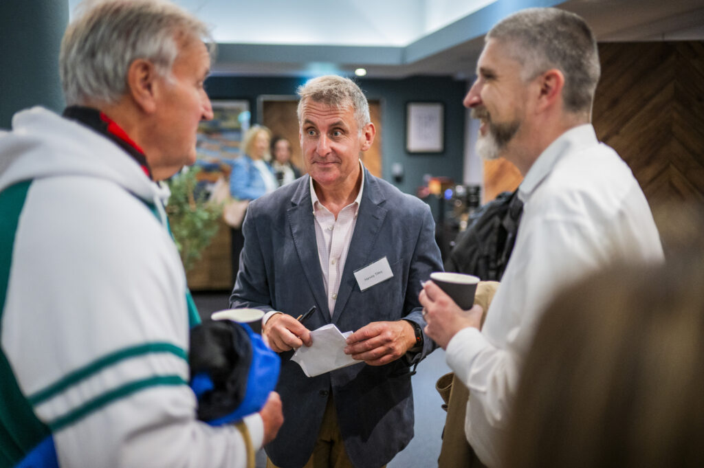 A man talks to two men.