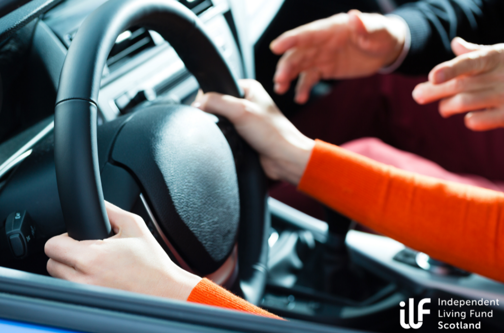 An inside shot of a car. A young pair of hands grips the wheel while another, older set, guide them.