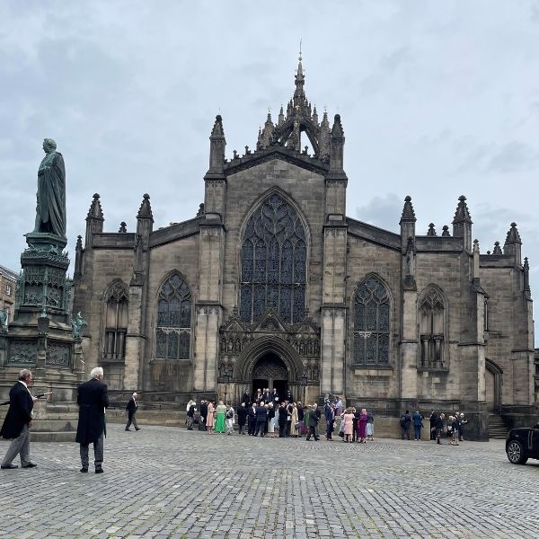 Photo of St Giles' Cathedral in Edinburgh on a grey, cloudy day, with a crowd of people gathered outside.