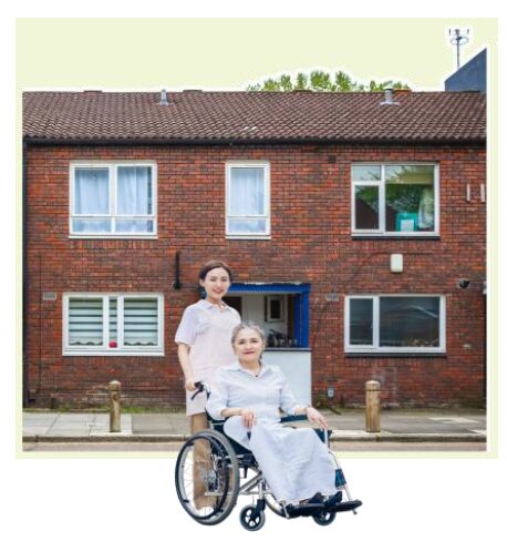 Red brick house with resident in a wheelchair and carer.