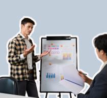 Man presenting at flipchart to other person on the right.