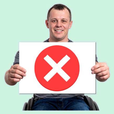 Man holds up a sign with a big red cross x on it.