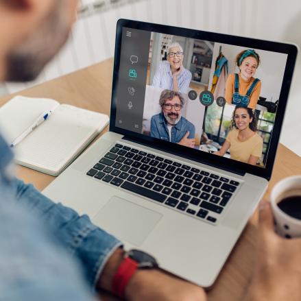Man on a laptop computer taking part in an online Teams meeting.
