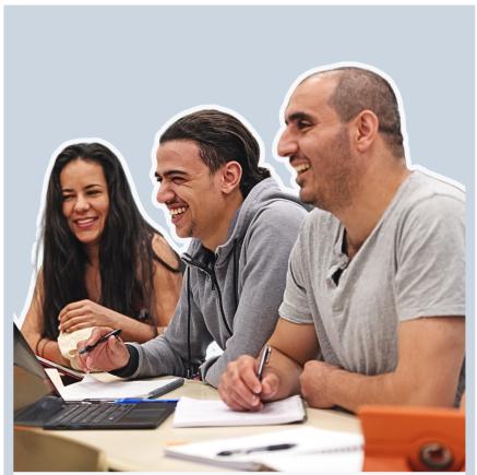 Three smiling people looking at documents on a table - Easy Read