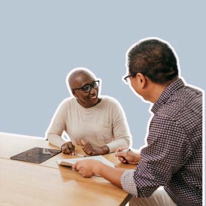 Two people looking at paper information at a table.