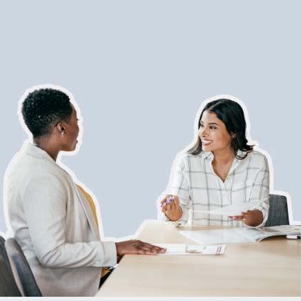 Two women talking over documents at a table