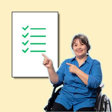 Woman wearing blue and in a wheelchair points at checklist with 4 green ticks