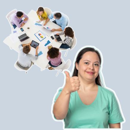 Woman in green with thumbs up with people meeting at a table behind her