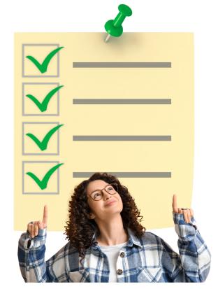 Woman in a checked shirt points at a yellow list above her head. It has a green pin and four green tick marks