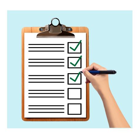 A hand is ticking off a checklist on a clipboard. There are green ticks on three items.