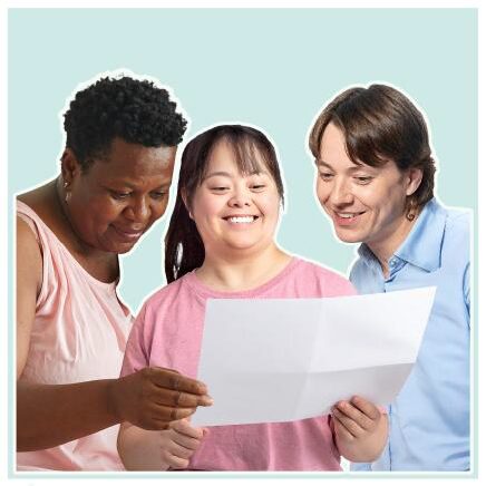 Three people looking at a paper and smiling.